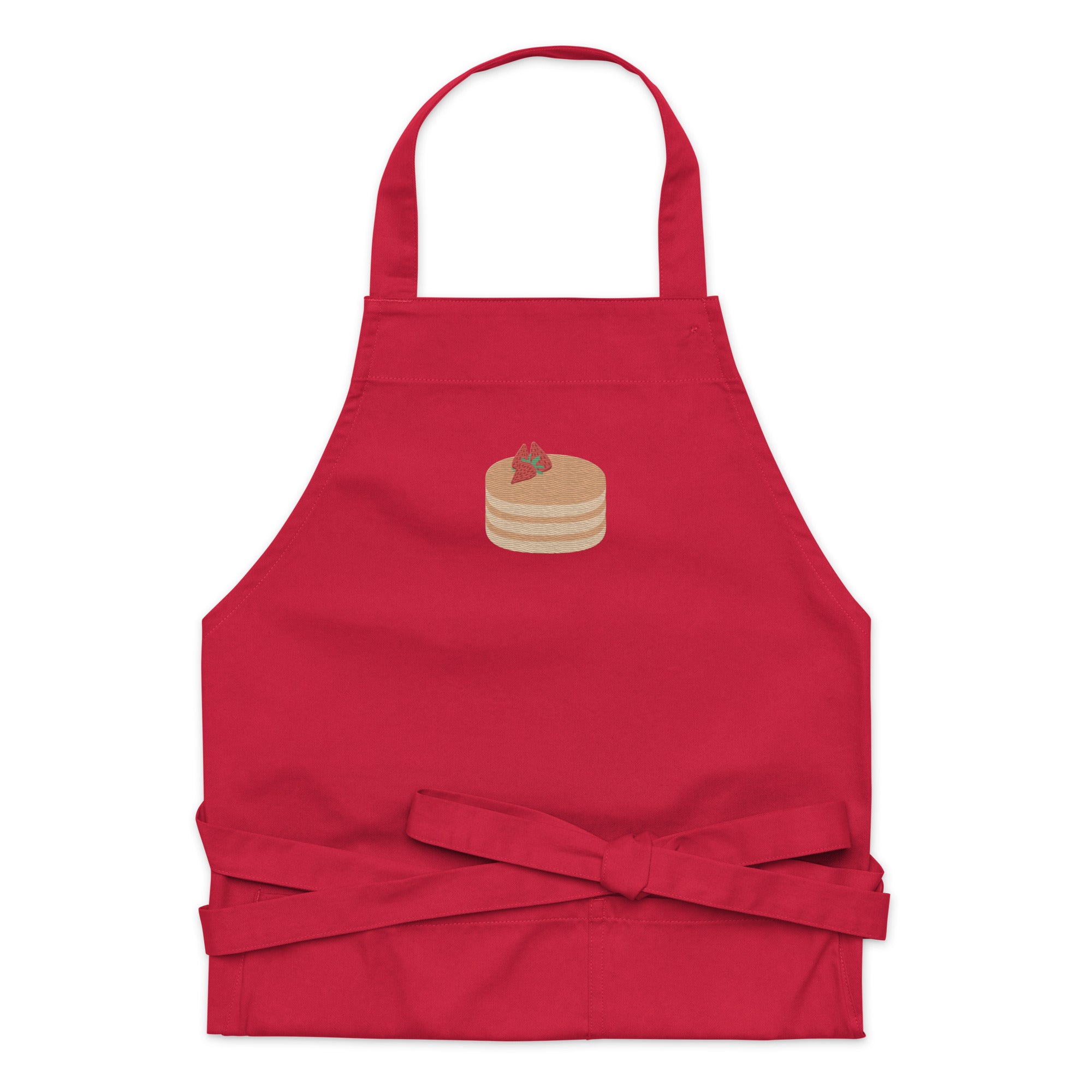 Kitchen apron embroidered on the front. The design is of pancakes with 3 strawberries on top, in a graphic are / vector art style. Apron features 2 front pockets and long straps to be tied behind the wearer in the usual manner. Unisex. One Size. Color: Red. Designed by Brekky Threads.