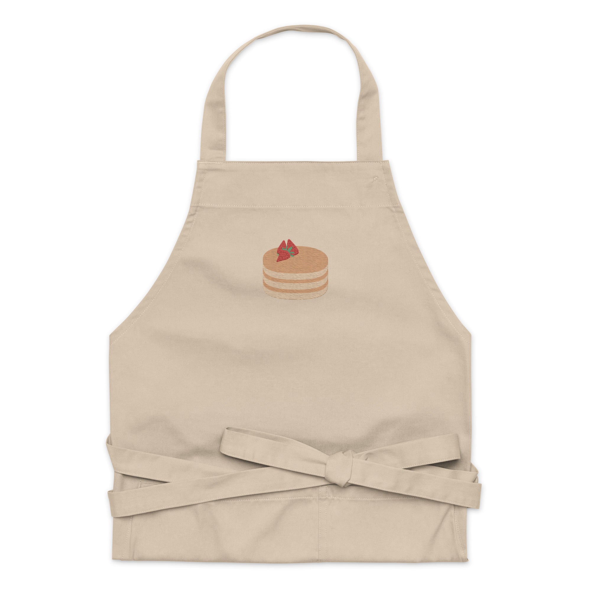 Kitchen apron embroidered on the front. The design is of pancakes with 3 strawberries on top, in a graphic are / vector art style. Apron features 2 front pockets and long straps to be tied behind the wearer in the usual manner. Unisex. One Size. Color: Rope (Beige). Designed by Brekky Threads.
