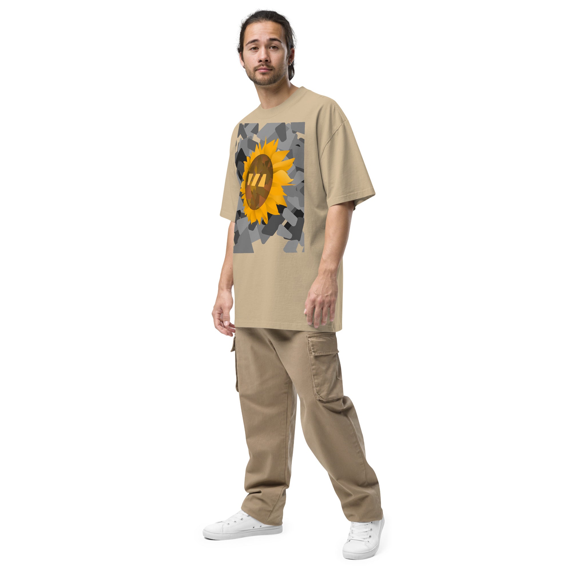 Man wearing the khaki Sun Flower brekky tshirt, from a side angle. Beige t-shirt with a sunflower graphic set on an urban black-and-white graphic made out of wedges. (Which is what the Brekky logo looks like) PS, he looks really cool.